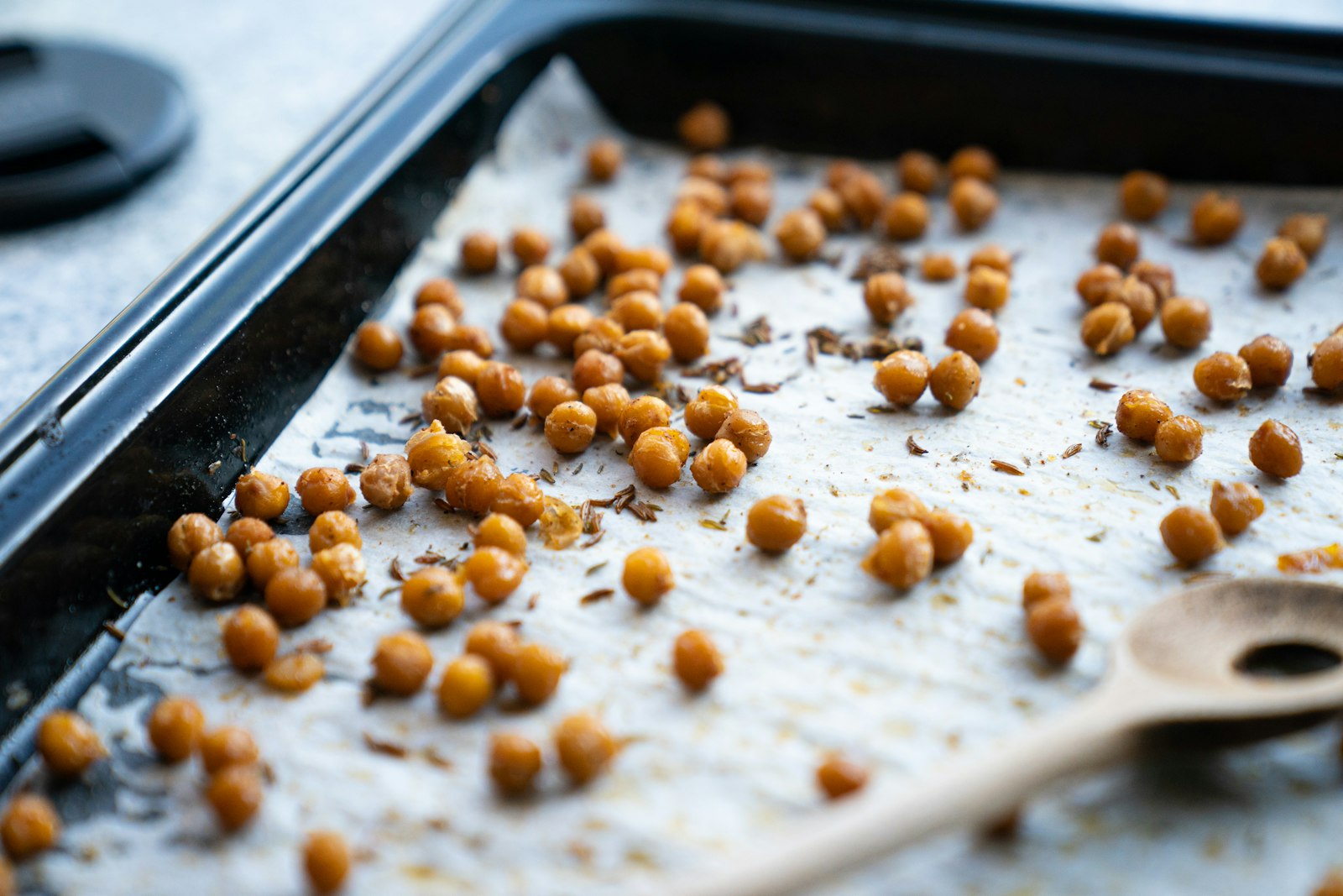 Crunchy roasted chickpeas spread on a baking tray
