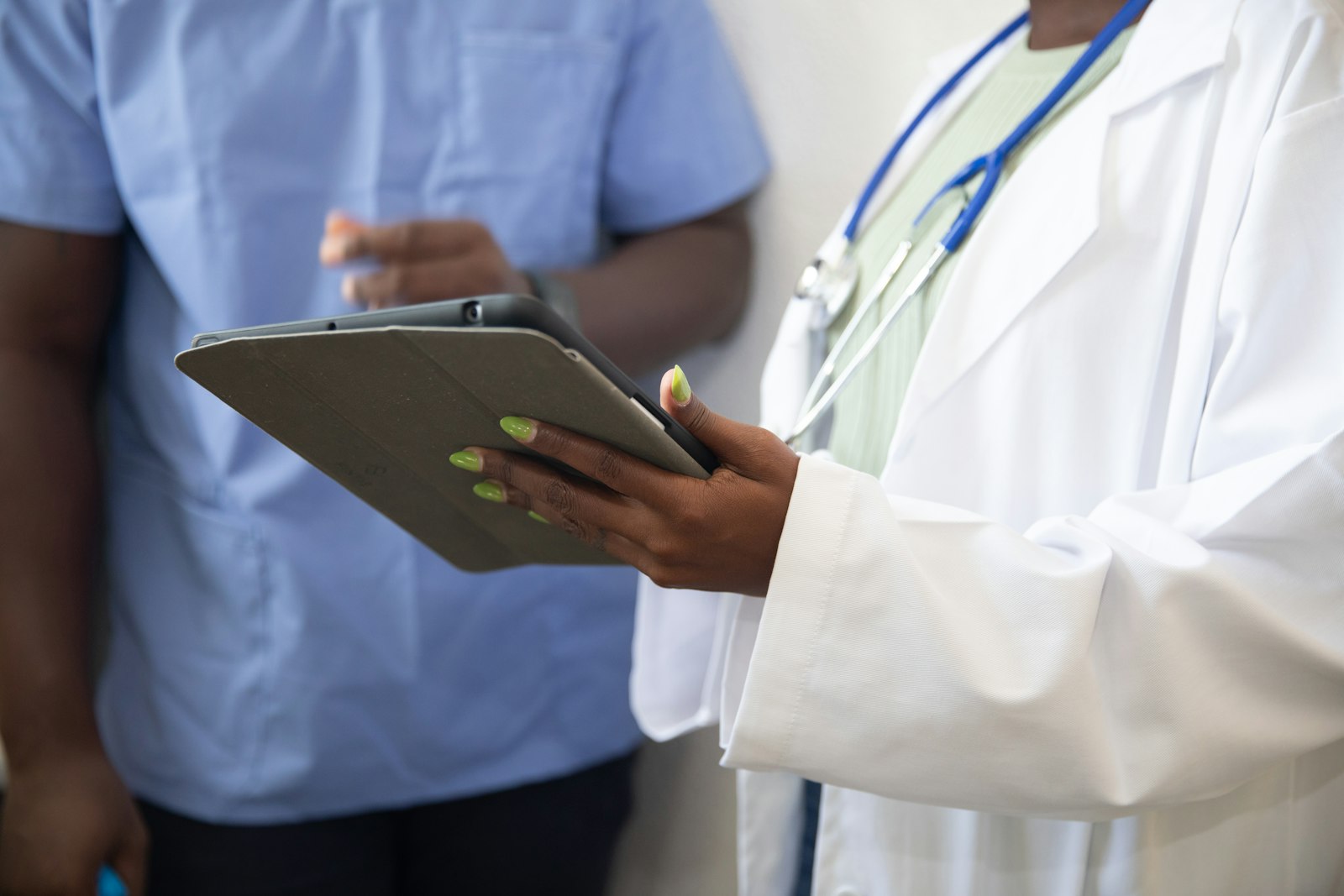 A doctor showing a patient information on a tablet screen