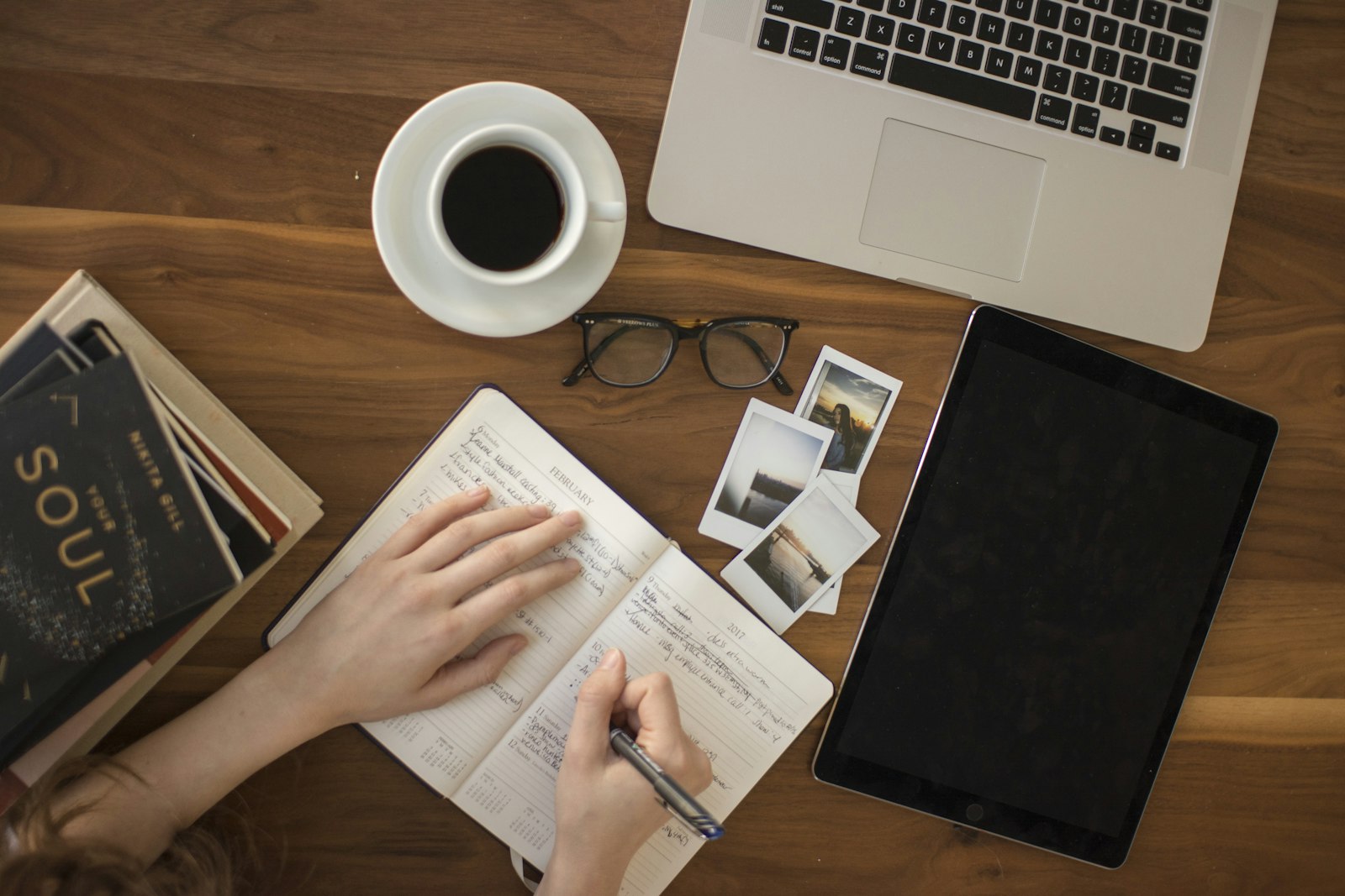 A hand writing notes with a ballpoint pen in an open notebook