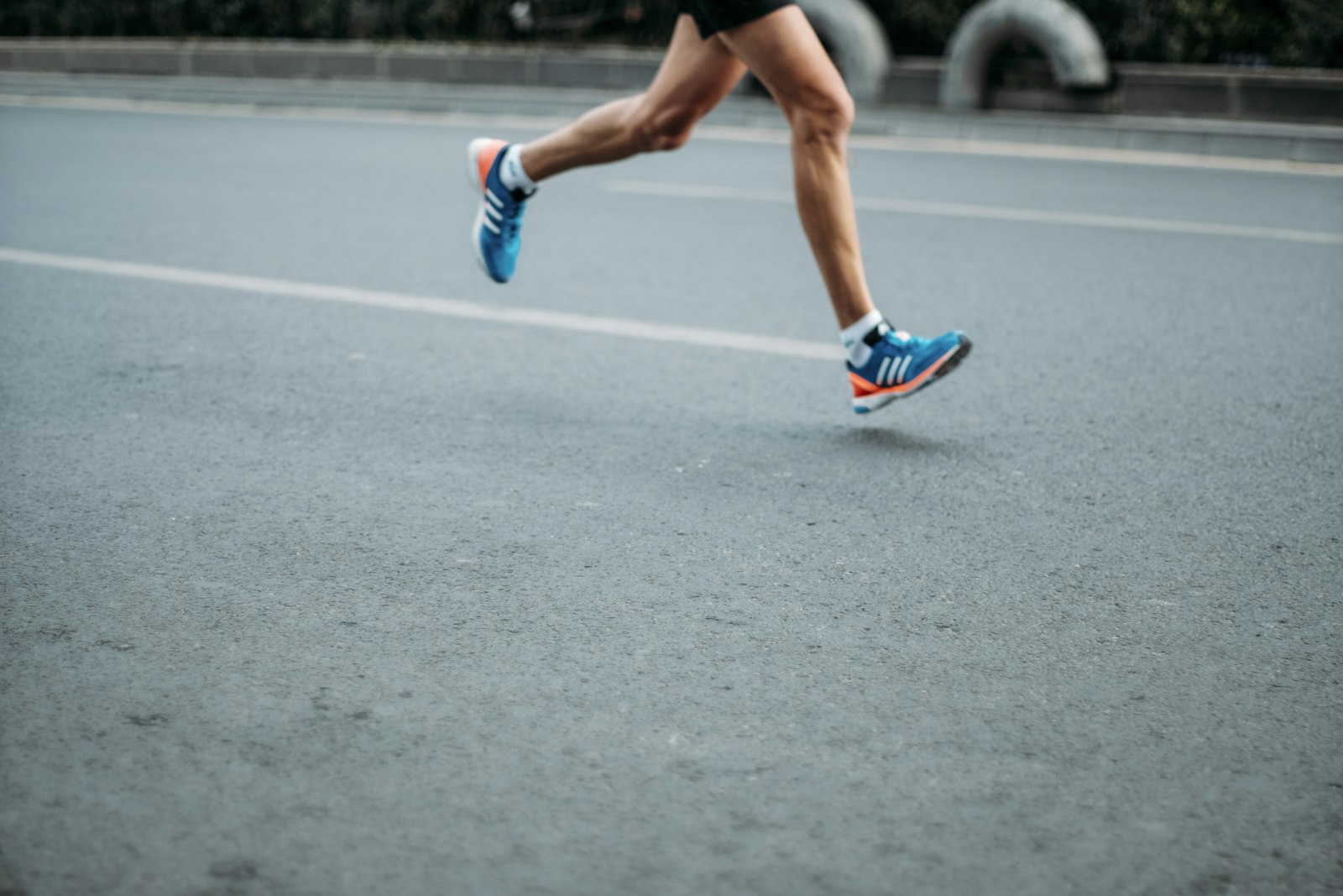 A pair of blue and white running shoes on a light background