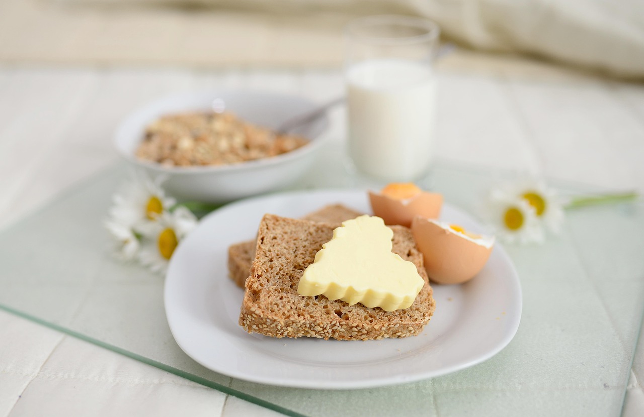A simple breakfast plate with bread, eggs and a glass of milk on a table