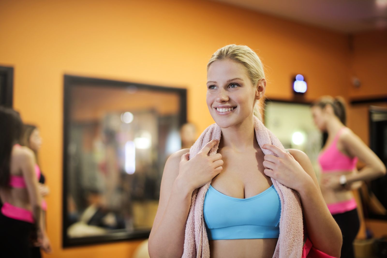 A smiling woman in sportswear taking a break during an indoor workout
