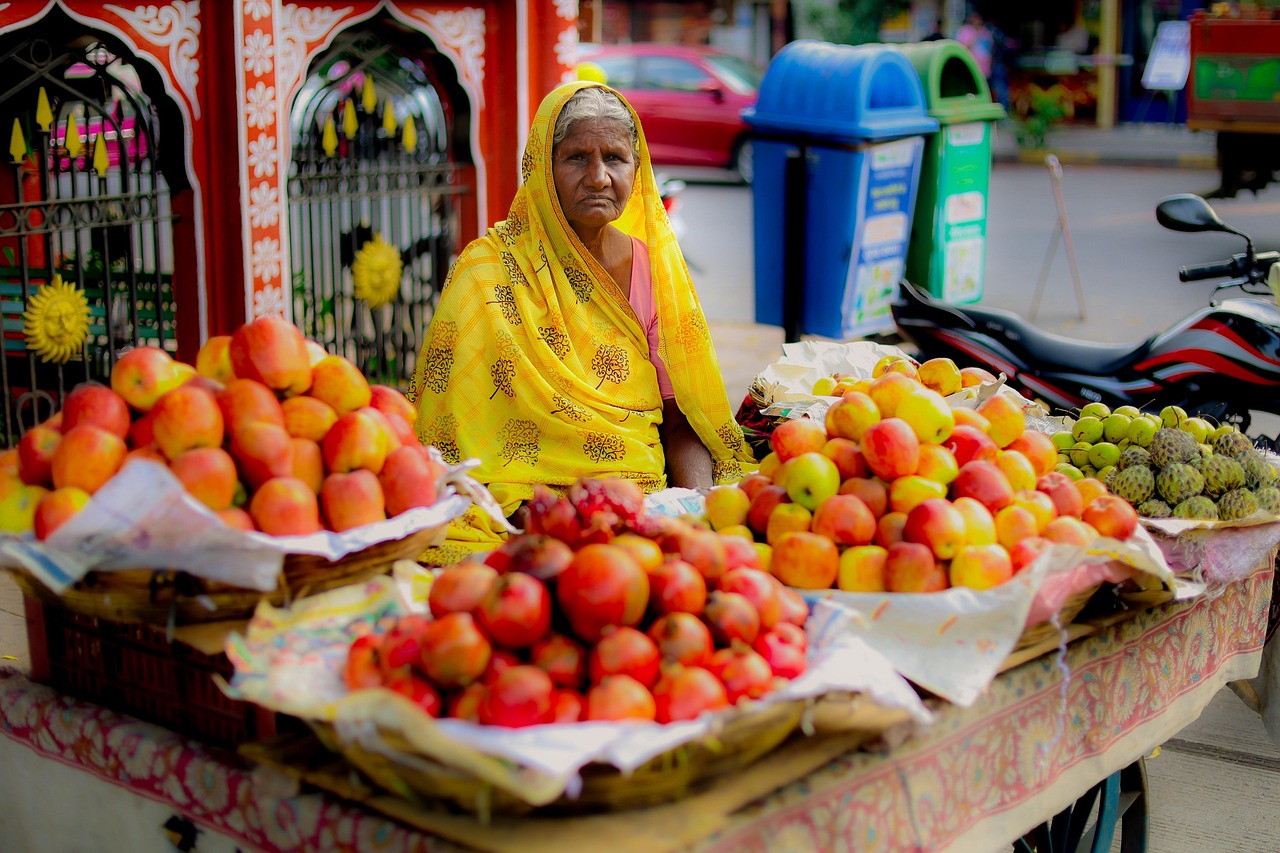 A street fruit stall piled with fresh strawberries and seasonal fruit