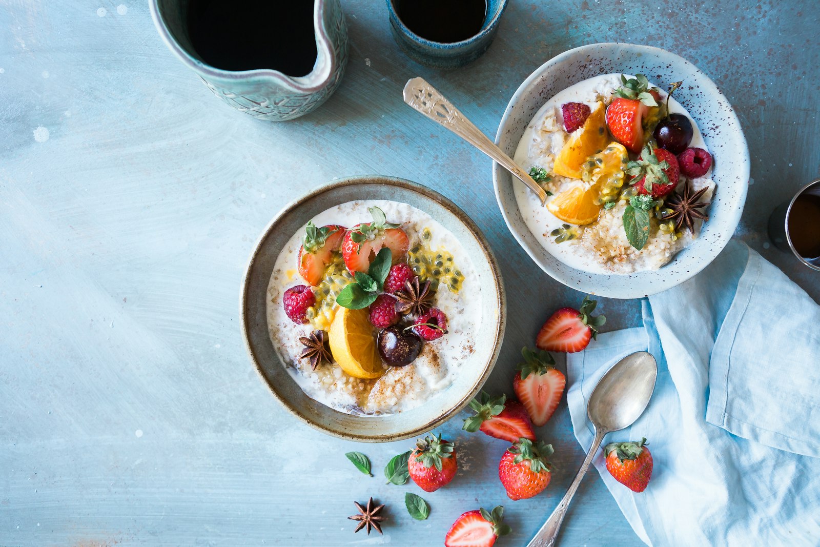 Two bowls of oatmeal topped with fresh fruit