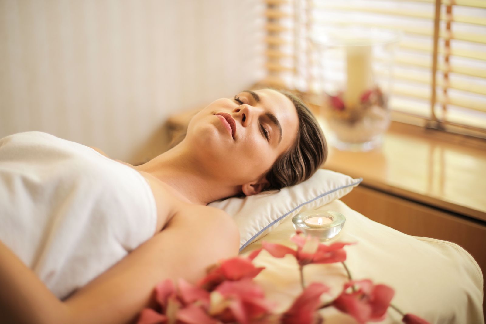 A woman lying back with her eyes closed, resting and relaxing