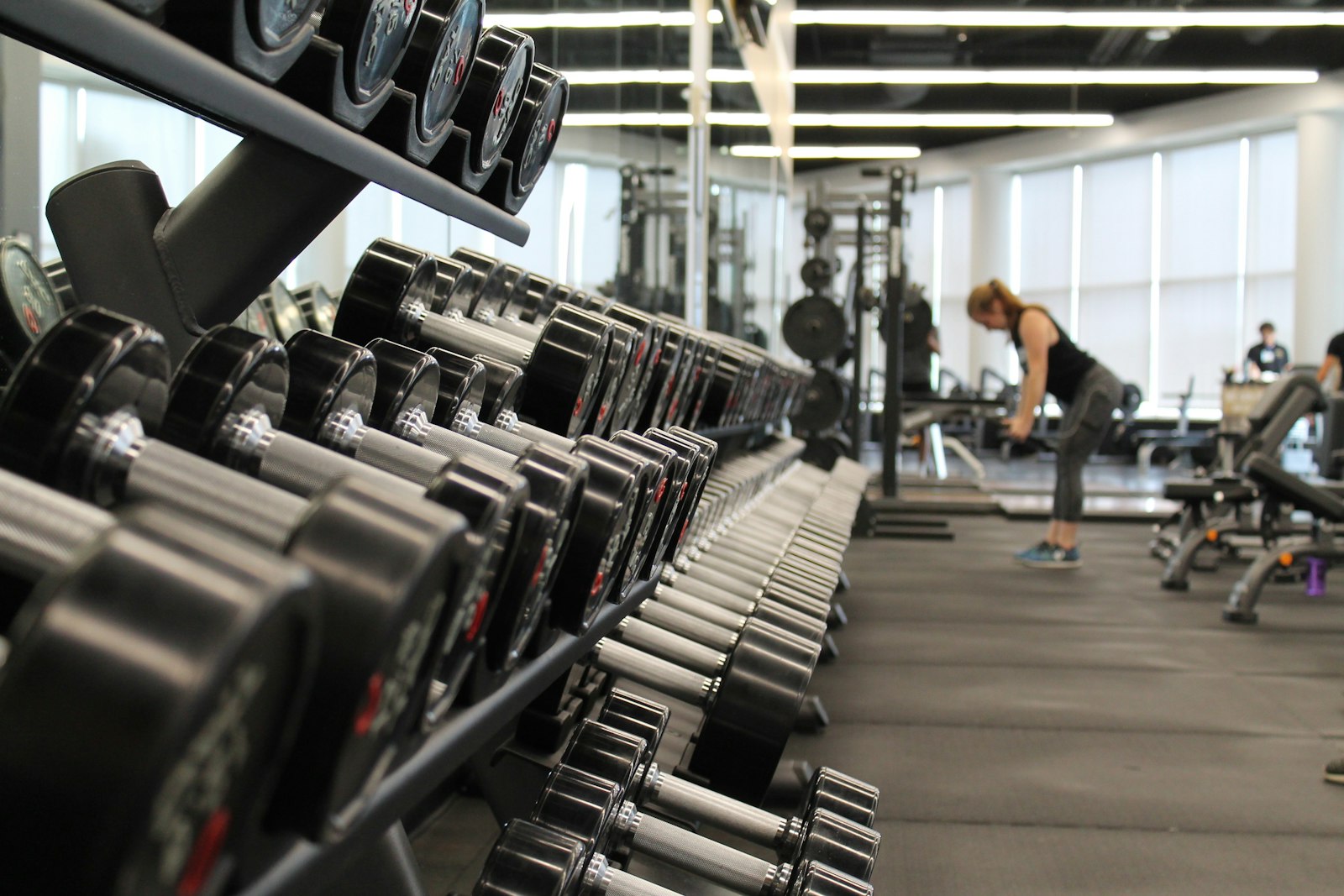 A woman standing in a gym surrounded by exercise equipment